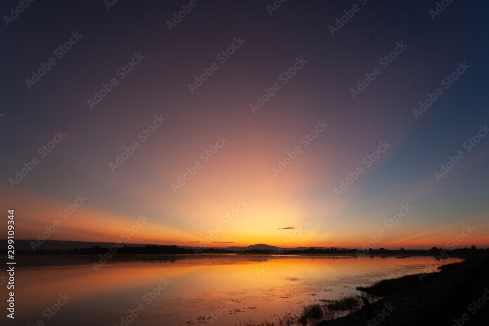 Beautiful sunset reflected in the lake.Fiery orange sunset sky. Beautiful sky