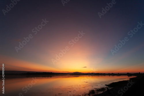 Beautiful sunset reflected in the lake.Fiery orange sunset sky. Beautiful sky