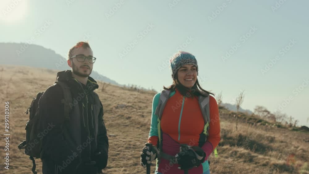 Happy hikers talking on mountain top. Slow motion shot of man and woman on mountain top. Happy hikers talking on mountain top. Slow motion shot of man and woman on mountain top.