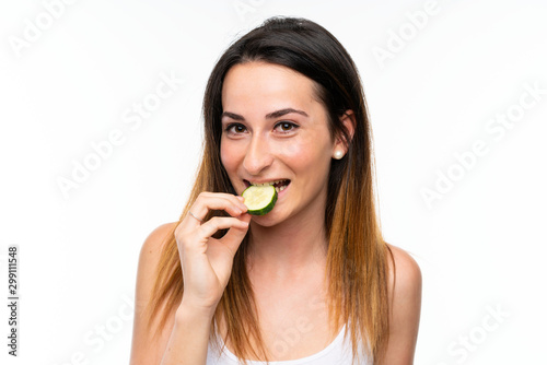 Beautiful young woman holding slices of cucumber over isolated white background