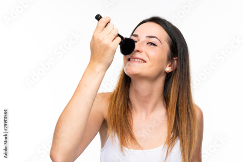 Young woman holding a lot of makeup brush over isolated white background