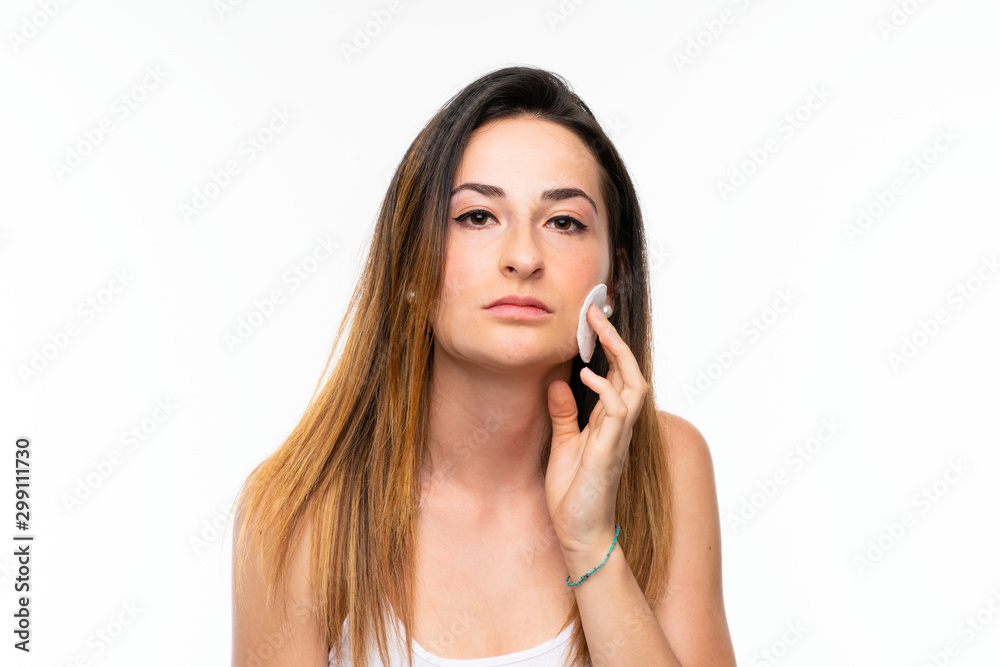 young woman removing makeup from her face with cotton pad young woman removing makeup from her face with cotton pad