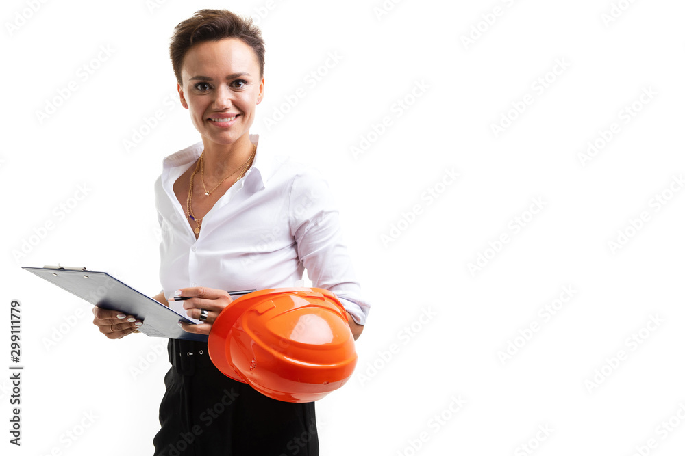 brunette engineer on a white background with an orange helmet on the elbow looks at the camera with a smile brunette engineer on a white background with an orange helmet on the elbow looks at the camera with a smile
