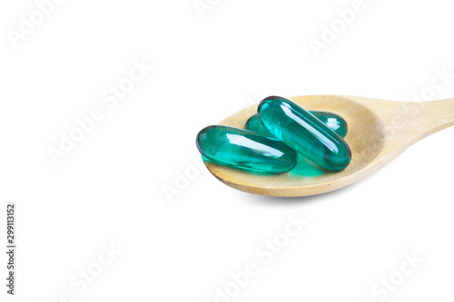 Aqua blue soft capsules on wooden spoon isolated on white background.File contains a clipping path.
