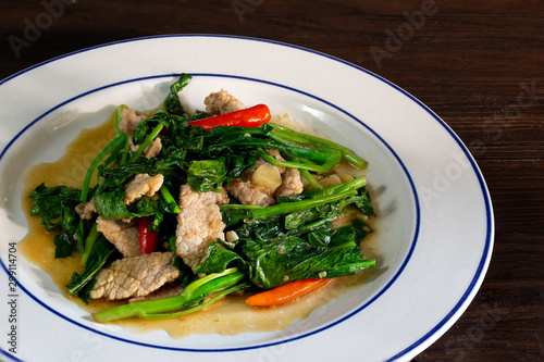 Stir fried kale with pork in white dish, Thai food