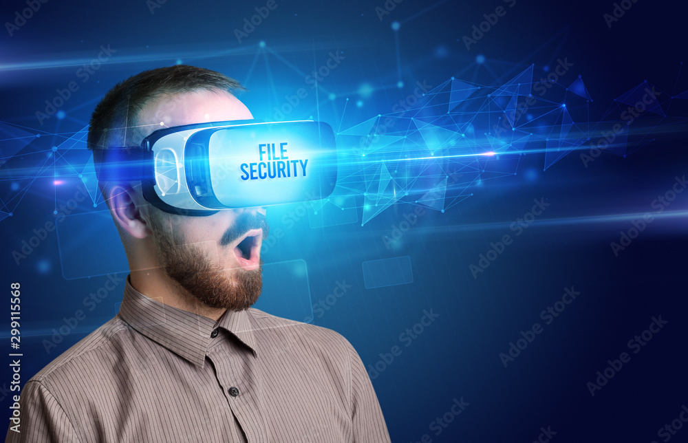 Businessman looking through Virtual Reality glasses with FILE SECURITY inscription, cyber security concept Businessman looking through Virtual Reality glasses with FILE SECURITY inscription, cyber security concept