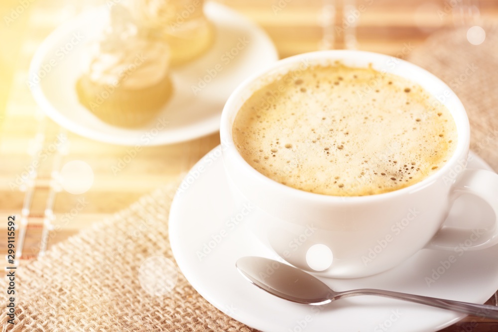 Cup of coffee and scattered coffee beans on wooden background Cup of coffee and scattered coffee beans on wooden background
