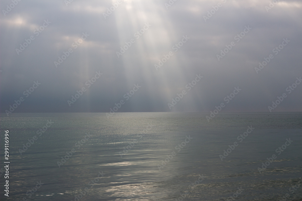  the rays of the sun break through the clouds at sea