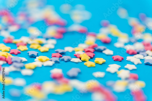 party, sweets and decoration concept - star shaped sugar sprinkles on blue background © Syda Productions