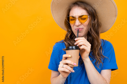 Slika na platnu disgruntled girl in a straw hat and glasses drinks tasteless coffee