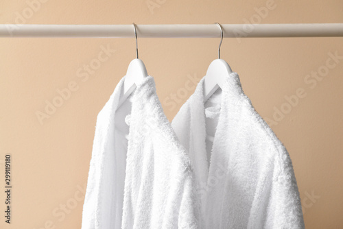 Clean bathrobes hanging on clothes rack © Pixel-Shot