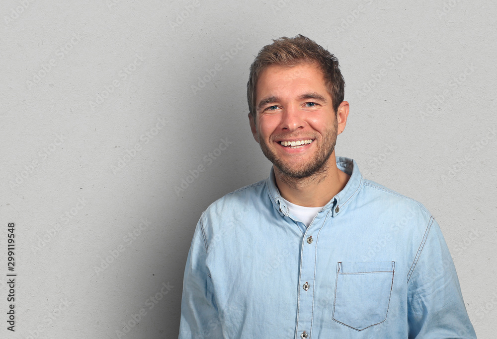 Young man in denim shirt is smiling - obrazy, fototapety, plakaty 
