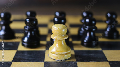 one white chess piece against a background of black pieces.