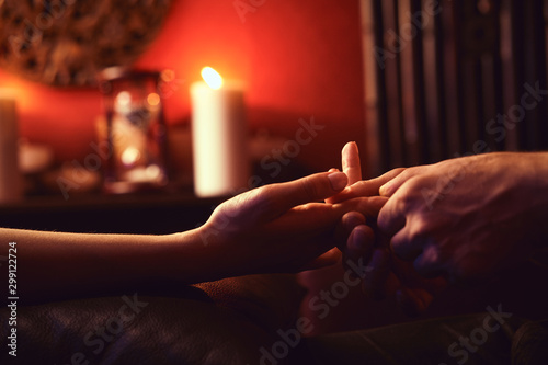 A man makes a woman acupressure fingers. hand massage with intimate lighting. Prelude before making love. Close. Complete relaxation photo
