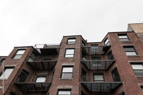 Rear view looking up of brick brownstones with metal balconies, horizontal aspect