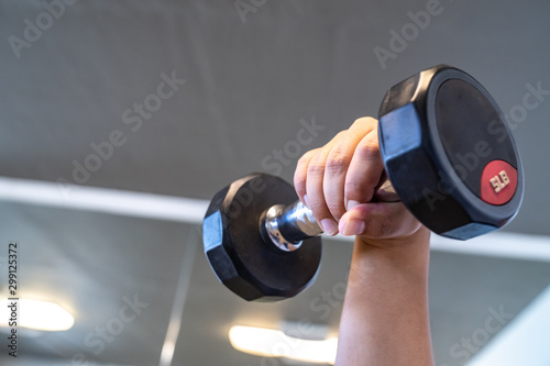 close up to black dumbbell in indoor fitness room., Thailand.
