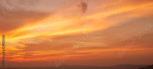 Dramatic sunrise sky over a mountain range.