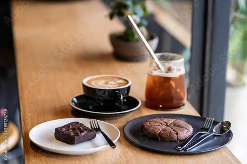 Fototapeta na wymiar Set of Dessert food and drink Latte coffee, Iced coffee, chocolate brownie cookies and cake on the wooden cafe table.
