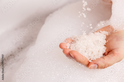 Fotografia white bath salt in a female hand