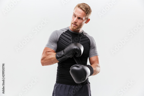 Confident young fit sportsman wearing boxing gloves