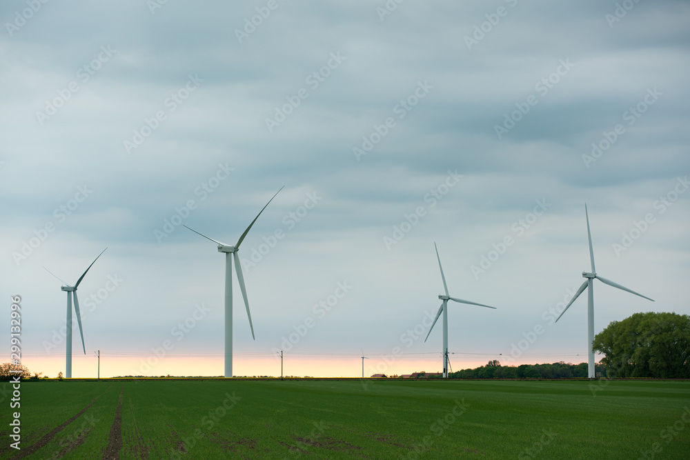 Wind turbines on the green field at cloudy day Wind turbines on the green field at cloudy day