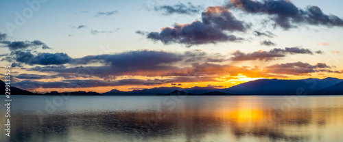 Fototapeta Naklejka Na Ścianę i Meble -  loch linnhe in the argyll region of the highlands of scotland during an autumn sunset showing golden light on the clouds and water and the islands of lismore and shuna