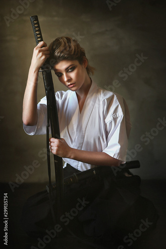 Studio portrait of young woman with sword