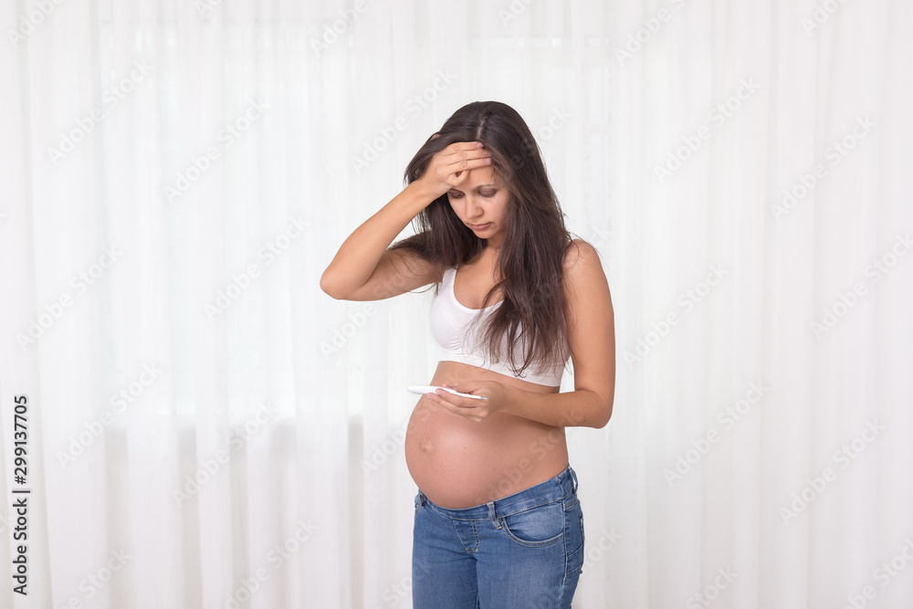 Pregnant woman with a thermometer and cough in her bedroom. Pregnancy health and medcine contest. Illness, cold, flu, allergy. Coronavirus disease. Covid-19 Pregnant woman with a thermometer and cough in her bedroom. Pregnancy health and medcine contest. Illness, cold, flu, allergy. Coronavirus disease. Covid-19