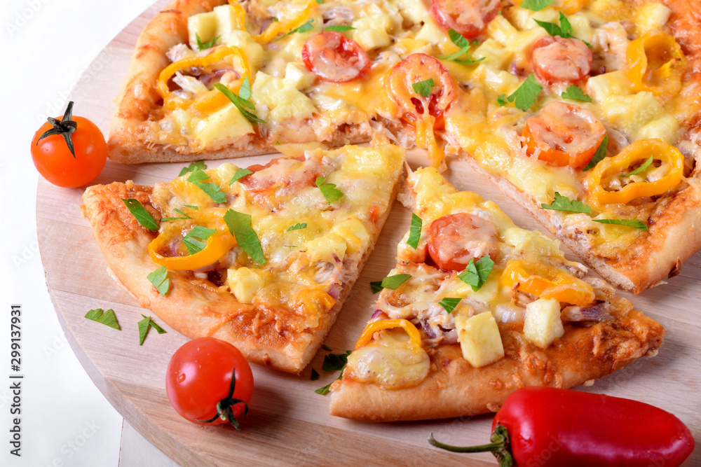 Pizza with chicken, cheese, tomatoes and bell peppers served on the round wooden board. Italian cuisine meal Pizza with chicken, cheese, tomatoes and bell peppers served on the round wooden board. Italian cuisine meal