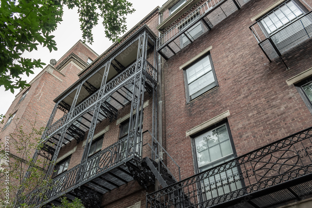 Elaborate balcony railings on the face of old brick apartment buildings, view looking up, horizontal aspect