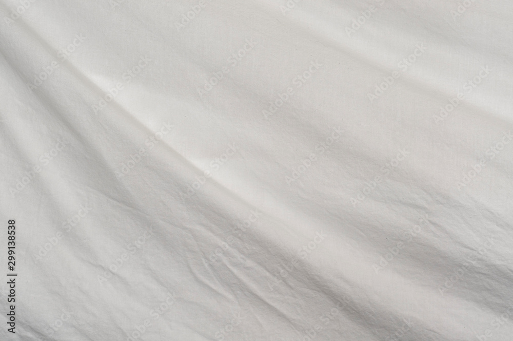 A gentle curve arcs through the frame from upper left to lower right of muslin cloth backdrop with small wrinkles. A gentle curve arcs through the frame from upper left to lower right of muslin cloth backdrop with small wrinkles.