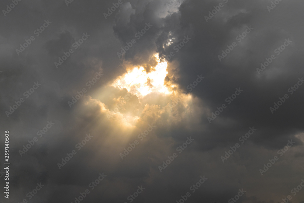 Beautiful gloden sun rays of light shining through the rain clouds in the sky, light from heaven, holy concept. Beautiful gloden sun rays of light shining through the rain clouds in the sky, light from heaven, holy concept.