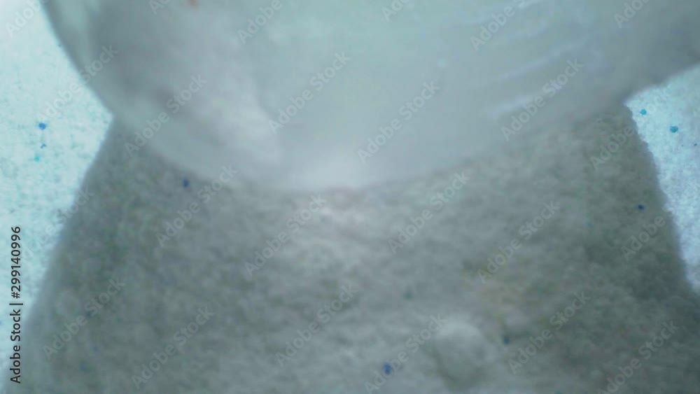White dry washing powder is poured into the container.close-up.shallow depth of field White dry washing powder is poured into the container.close-up.shallow depth of field