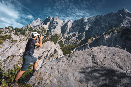 Photographer taking photos in front of impressive mountainscape