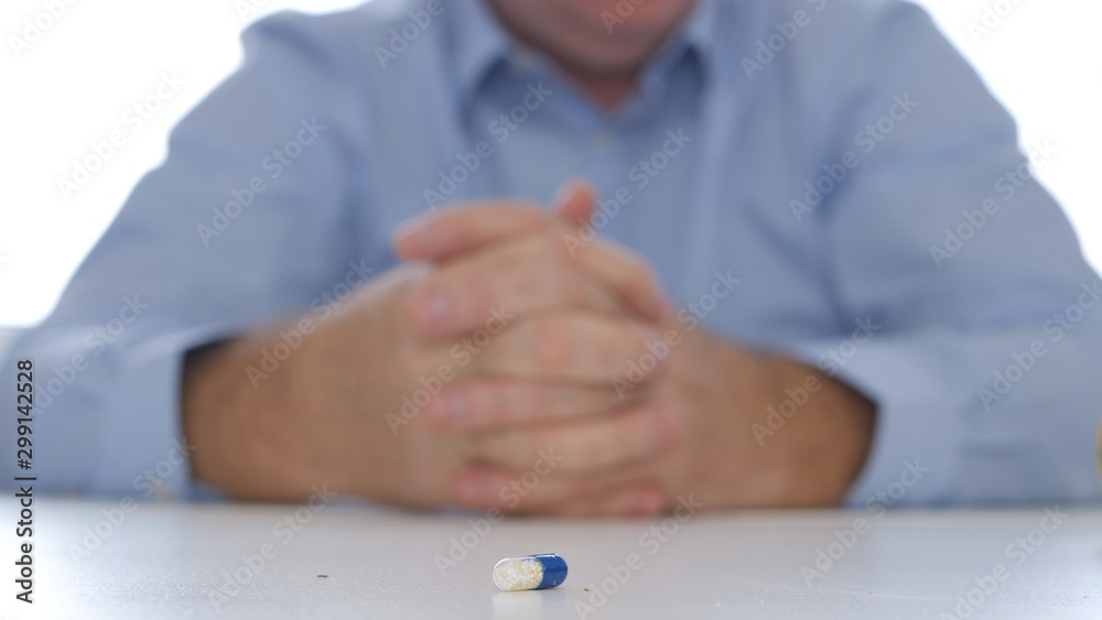 Image with a Suffering Patient Looking to a Medical Pill from the Table Image with a Suffering Patient Looking to a Medical Pill from the Table