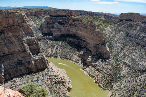 Single boat speeds through green Bighorn River in Wyoming