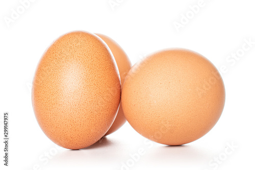 Group of three whole chicken eggs isolated on white background