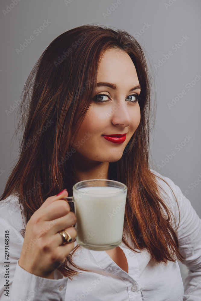Cheerful girl holding milk mug in hand Cheerful girl holding milk mug in hand