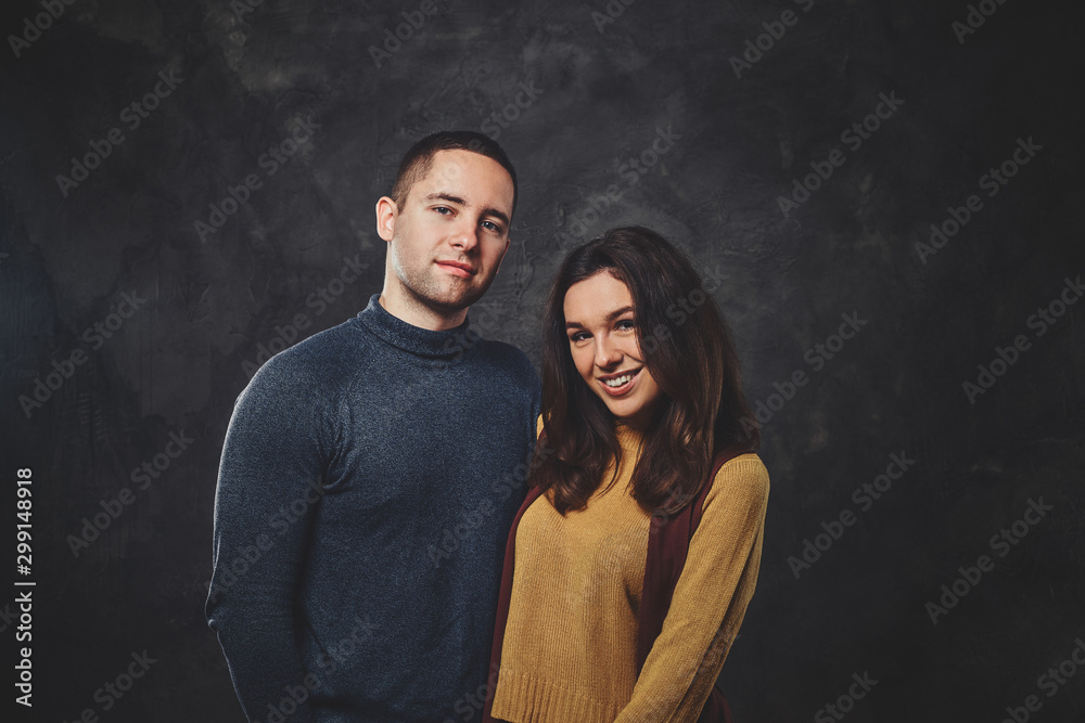 Charming happy couple is posing for photographer at photo studio. Charming happy couple is posing for photographer at photo studio.