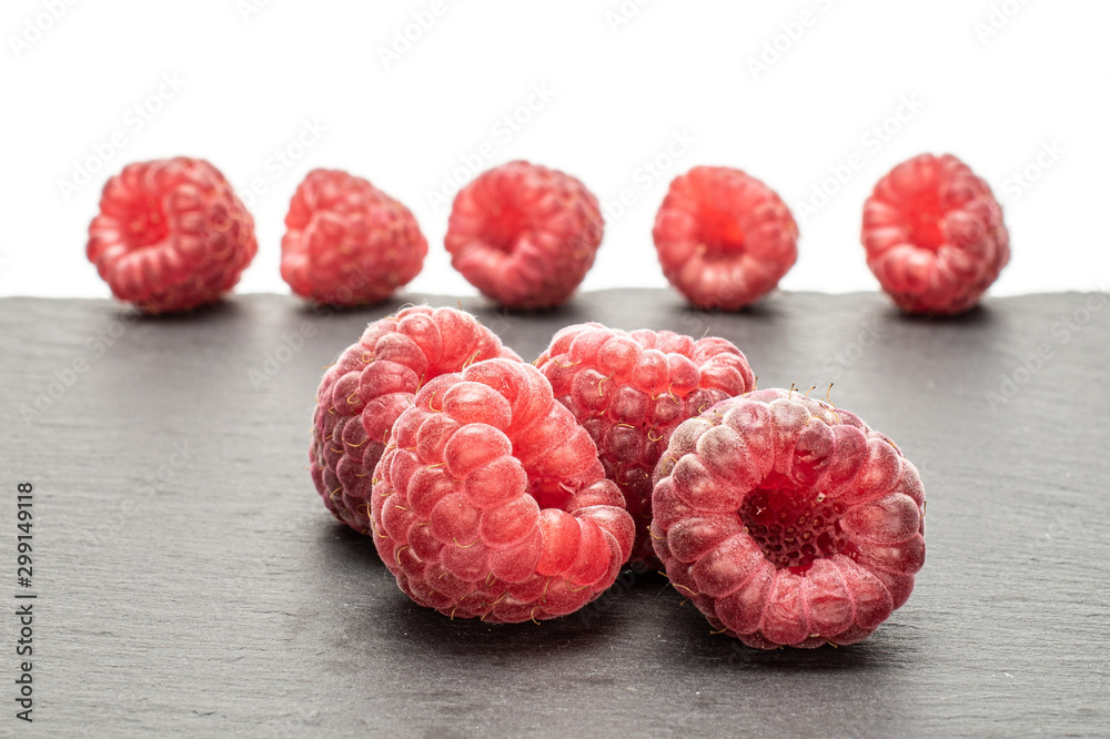 Group of two whole fresh crimson raspberry with steel spoon isolated on white background Group of two whole fresh crimson raspberry with steel spoon isolated on white background