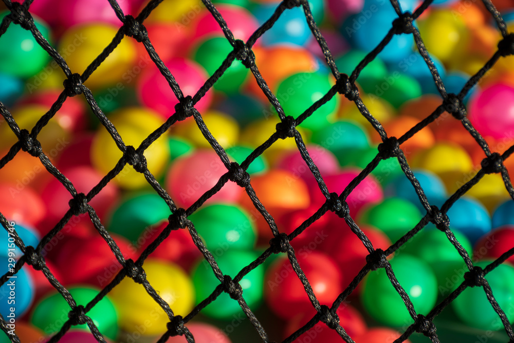 Fototapeta premium The net rope and colorful ball in children's playroom. Tight knot is used for safety barrier net. Children's playground