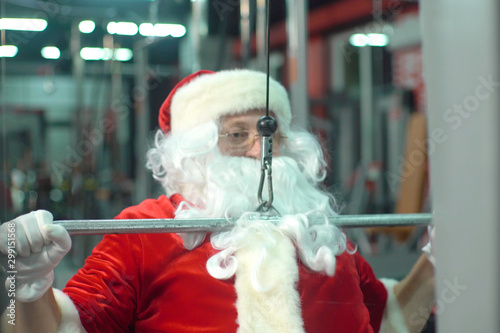Santa Claus training at the gym on Christmas Day. exercise-machine.