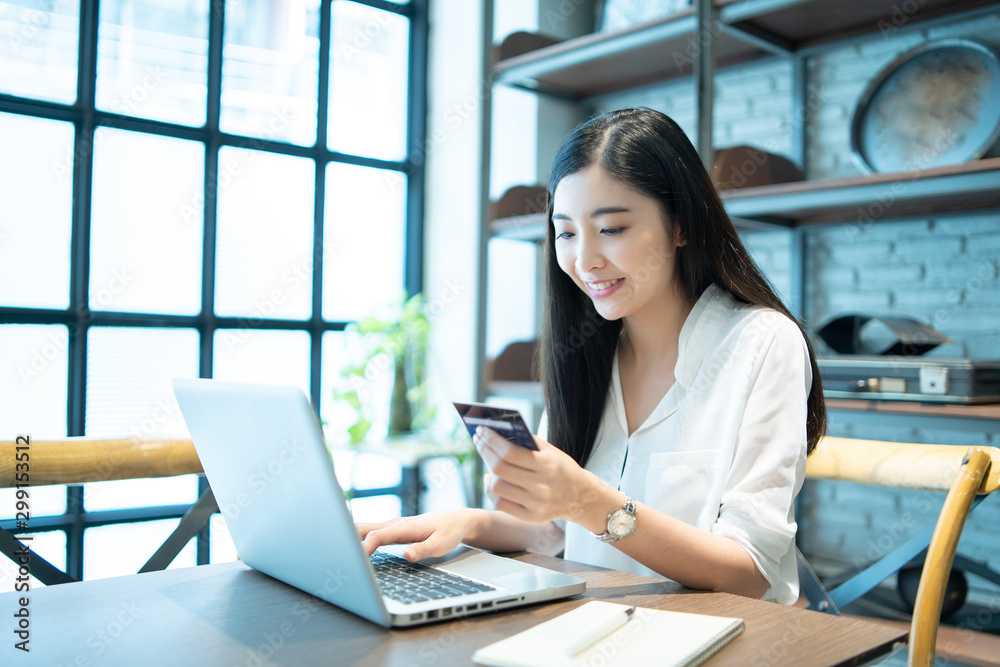 Technology, Online shopping, Digital banking, home lifestyle concept, a beautiful Smiling Asian woman with a laptop computer and credit card at home for business payment, career, e-commerce trading Technology, Online shopping, Digital banking, home lifestyle concept, a beautiful Smiling Asian woman with a laptop computer and credit card at home for business payment, career, e-commerce trading