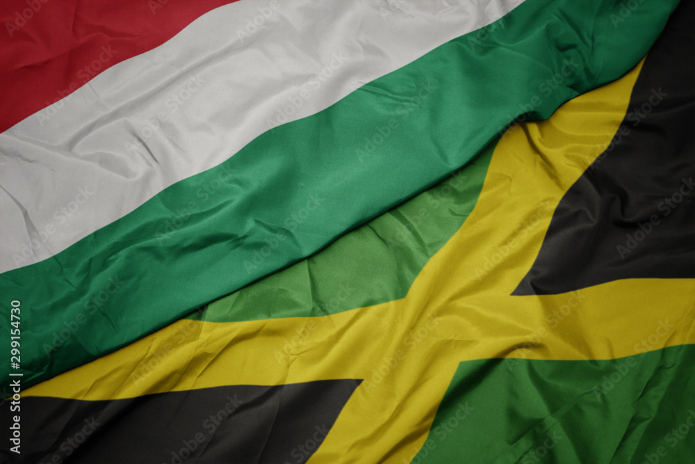 Obraz premium waving colorful flag of jamaica and national flag of hungary.