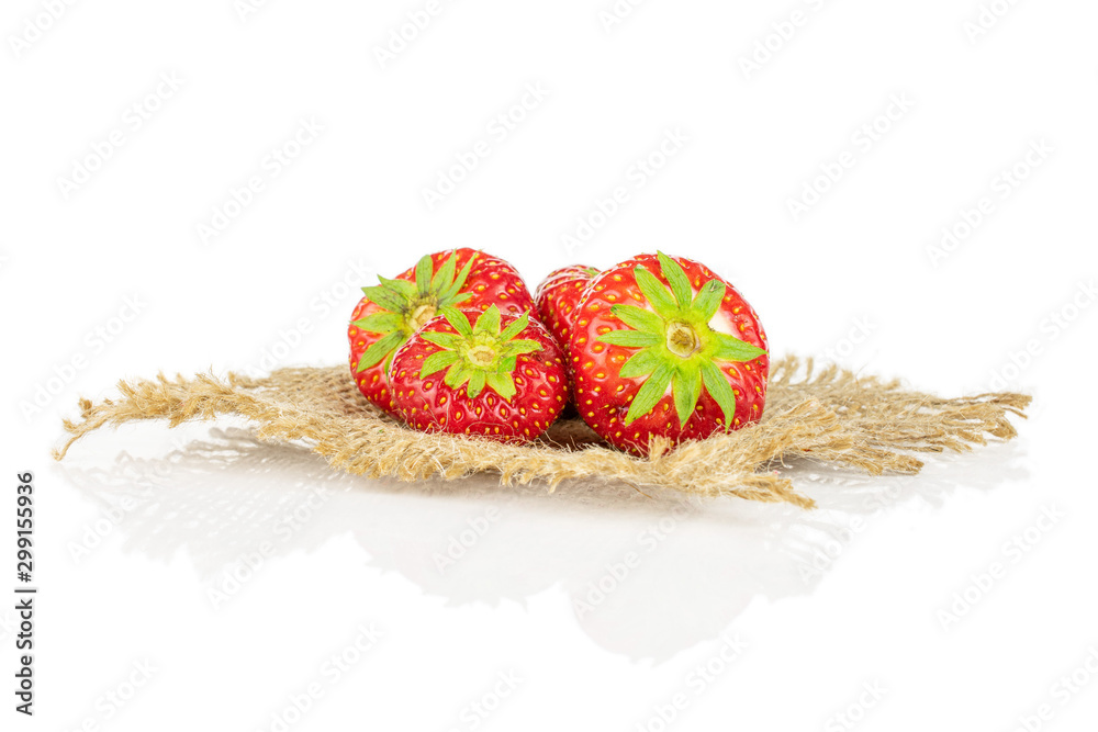 Group of four whole fresh red strawberry on natural sackcloth isolated on white background Group of four whole fresh red strawberry on natural sackcloth isolated on white background