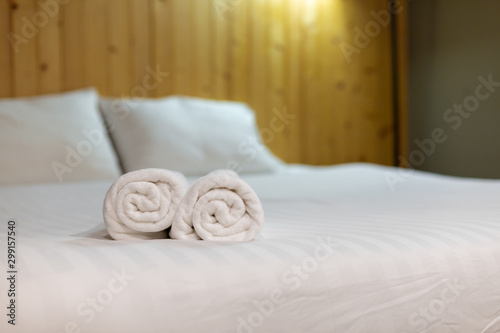 White towel on bed in guest room for hotel customer.