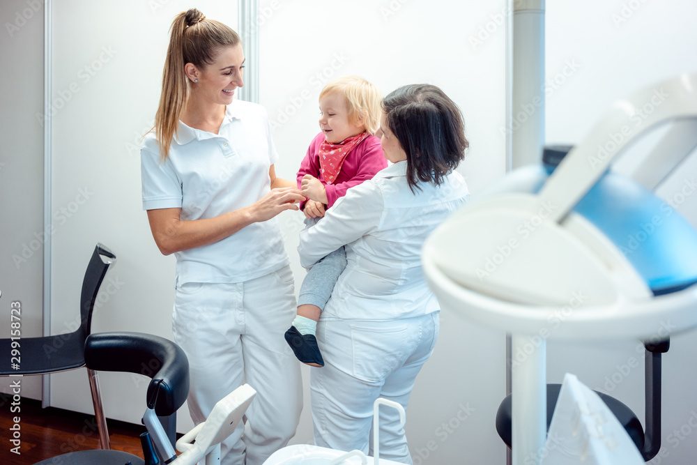 Dentist and her assistant with child in the office Dentist and her assistant with child in the office