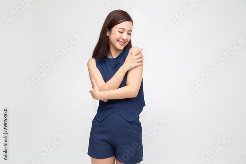 Happy young casual asian woman hugging herself isolated on white background. Love yourself concept © comzeal