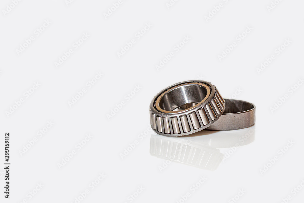 Angular contact bearing on a white background with reflection, consisting of two parts. Angular contact bearing on a white background with reflection, consisting of two parts.