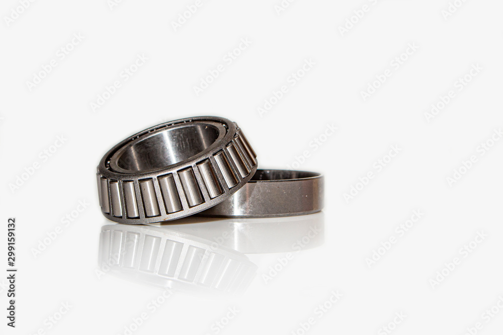 Angular contact bearing on a white background with reflection, consisting of two parts. Angular contact bearing on a white background with reflection, consisting of two parts.